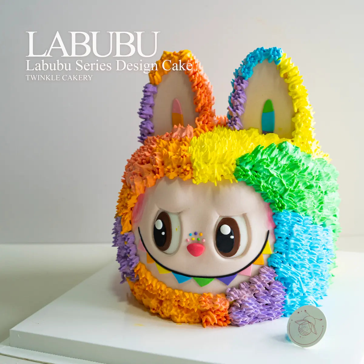 Colorful cake designed like a cartoon character with rainbow-colored ears, featuring the brand 'LABUBU'. Delivery across Selangor