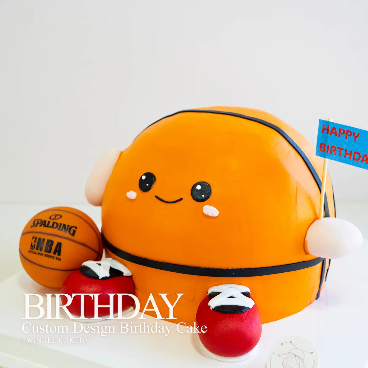 Custom design birthday cake shaped like a basketball with a smiling face, holding a small basketball. Delivery across Kuala Lumpur and Selangor