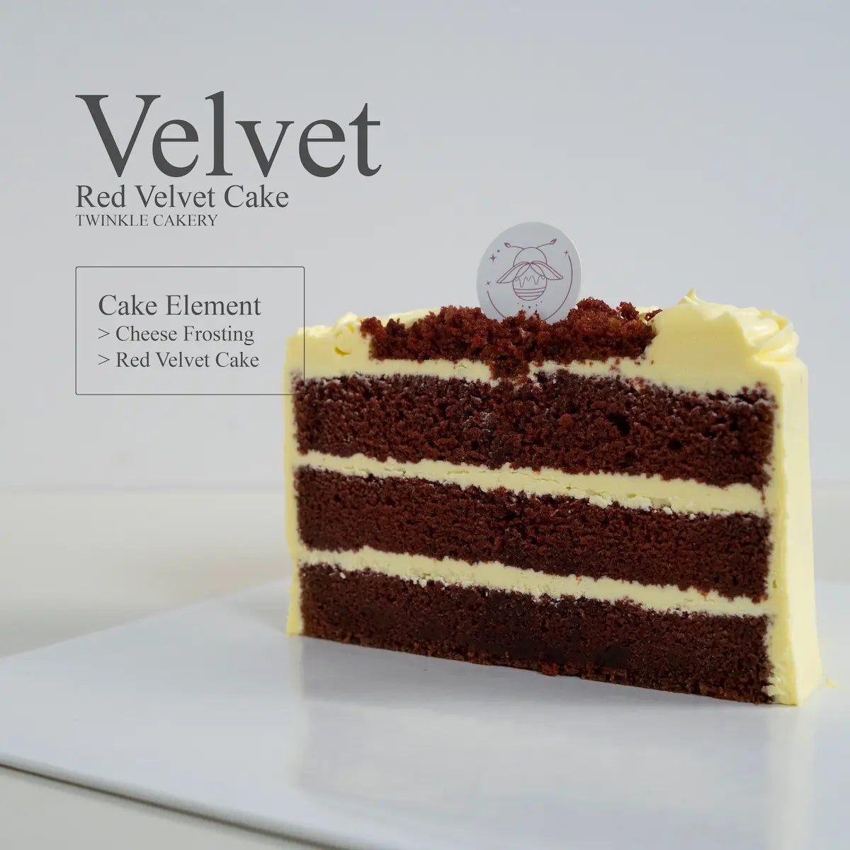 A cut slice of moist traditional Red Velvet cake showing deep red cocoa sponge layers and rich cream cheese frosting filling, baked in Selangor
