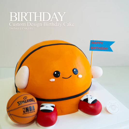 Custom birthday cake designed like a basketball with a cartoon face, surrounded by smaller basketballs and shoes. Delivery across Selangor and Kuala Lumpur