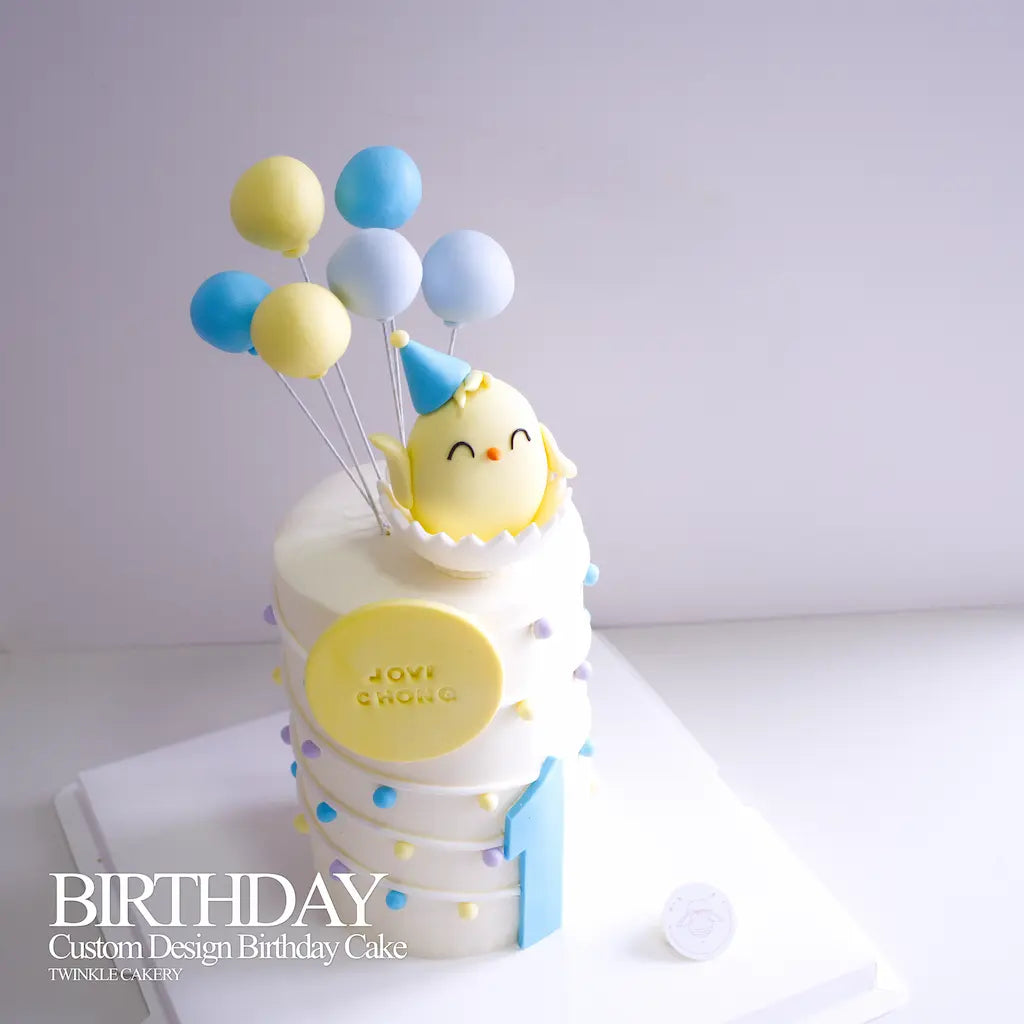 Close-up of hand-sculpted edible fondant chick peeking out from an eggshell. 