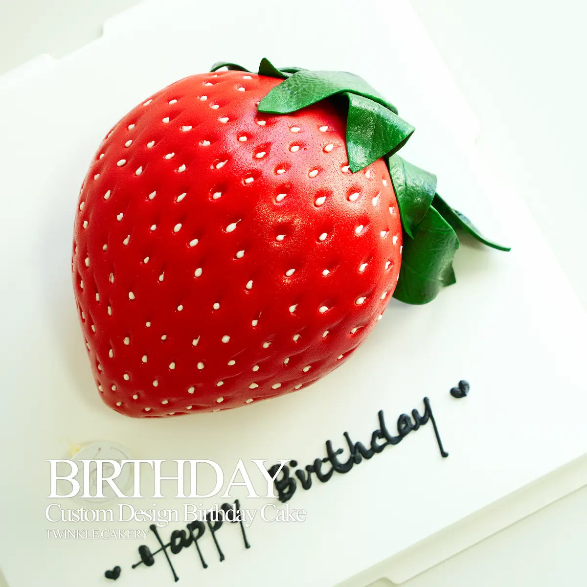 Detailed handmade fondant leaves on top of a realistic strawberry character cake.