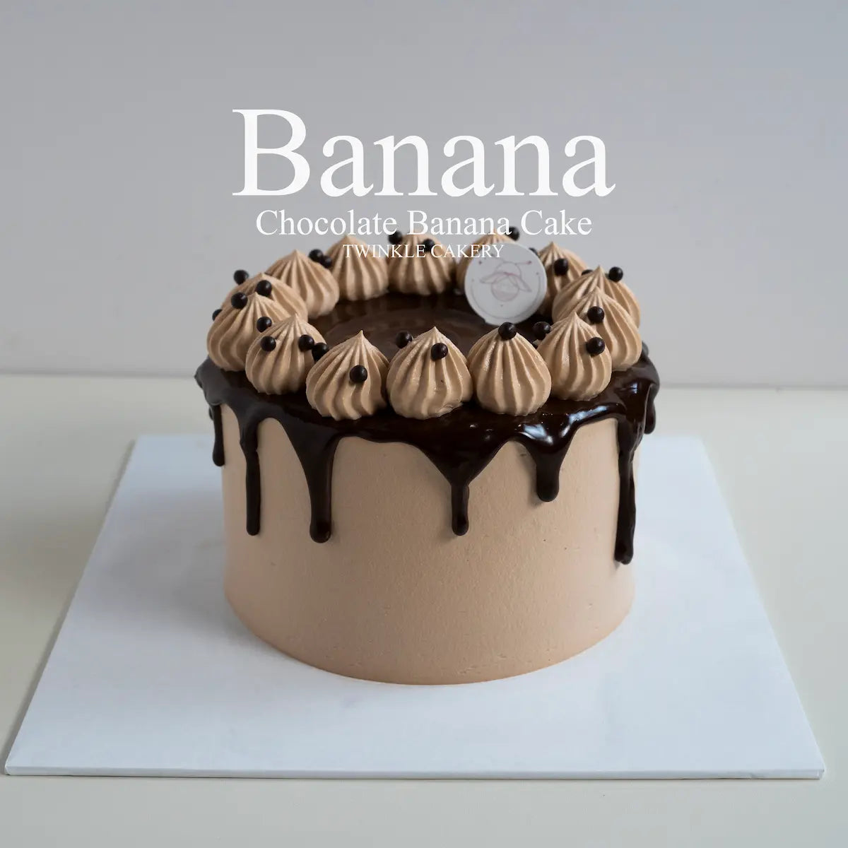 Premium chocolate banana cake coated in fresh cream with chocolate ganache drip details by Twinkle Cakery KL.