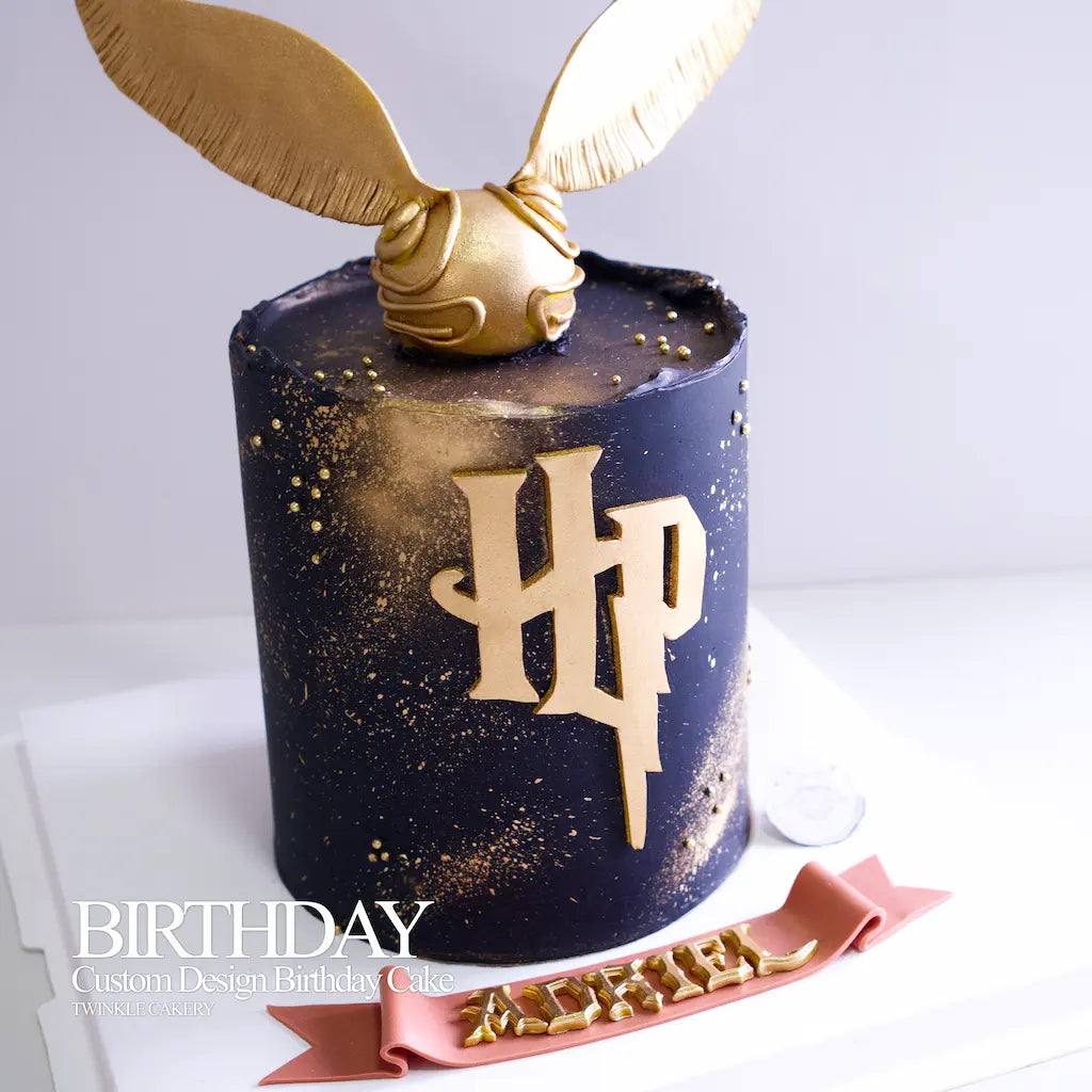 Handmade edible fondant Golden Snitch topper on a gold Harry Potter cake.
