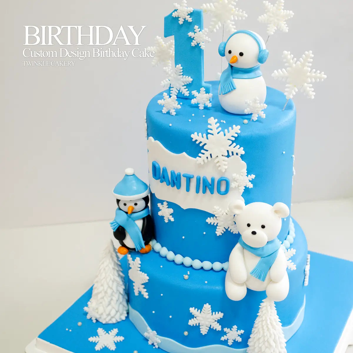 Hand-sculpted fondant penguin, polar bear, and snowman characters on a custom birthday cake in Kuala Lumpur