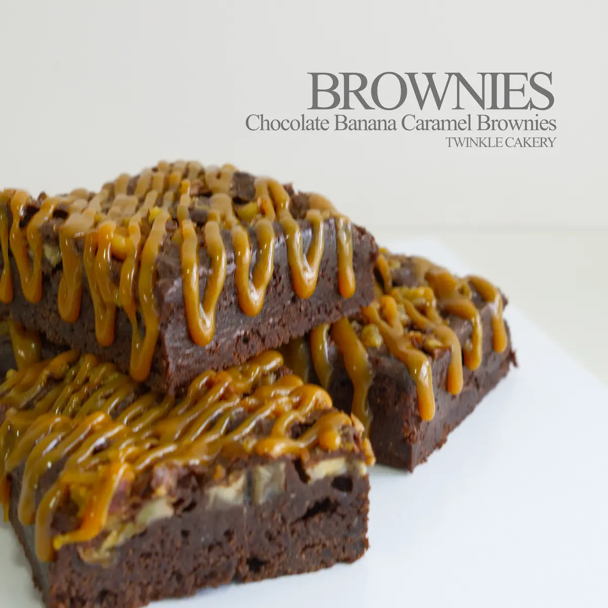 Cross-section of fudgy dark chocolate brownie filled with fresh banana and topped with caramel sauce.