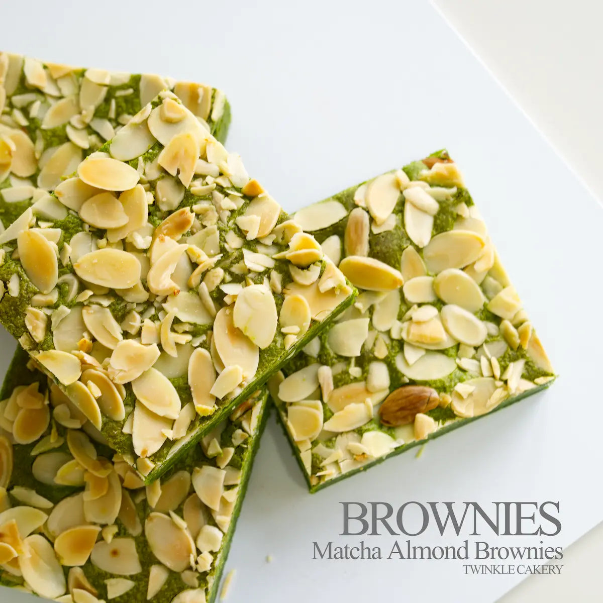 Cross-section showing dual layers: fudgy matcha white chocolate brownie base topped with almond flakes.
