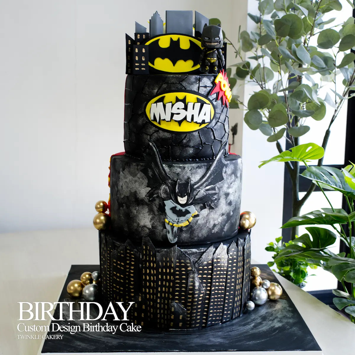 Detailed hand-sculpted 2D fondant Batman character on the middle layer of a Justice League cake.