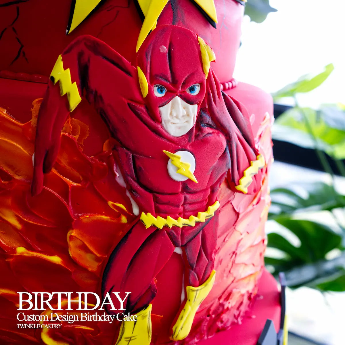 Detailed hand-sculpted 2D fondant The Flash character on the middle layer of a Justice League cake.