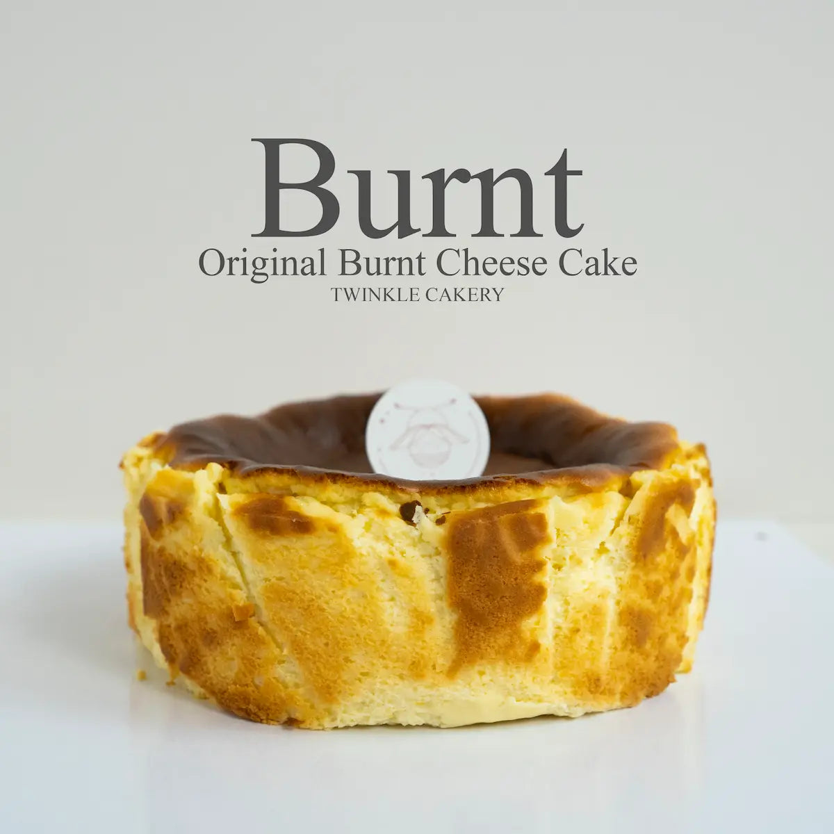 Original Basque burnt cheesecake with a deeply caramelized top on parchment paper by Twinkle Cakery Kuala Lumpur.