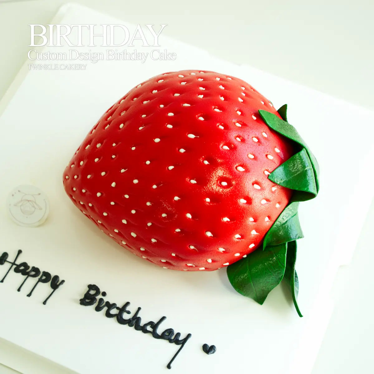 Close-up of handcrafted fondant seeds and texture on a 3D strawberry cake.