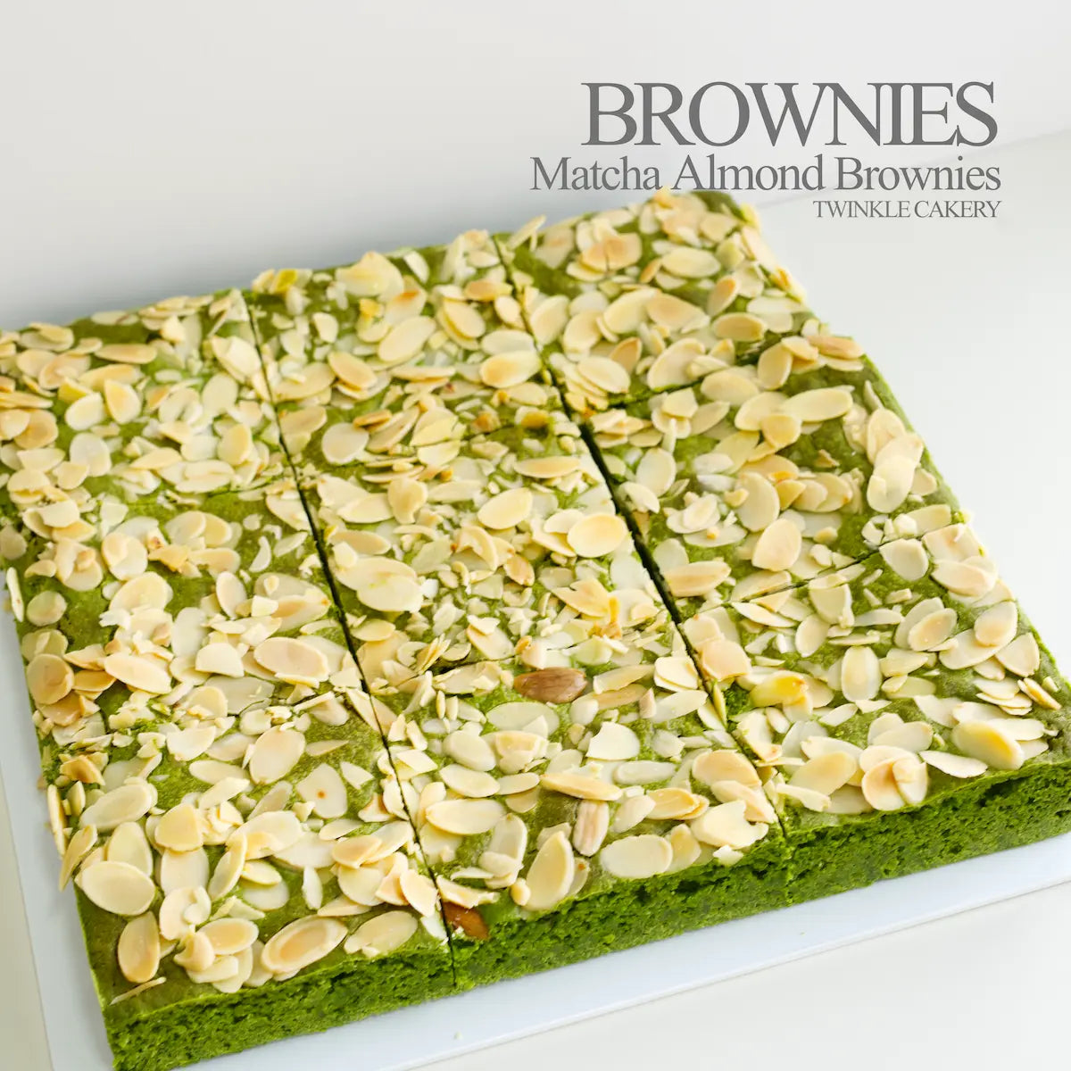 Macro detail of golden toasted almond flakes scattered over a vibrant green matcha brownie base.