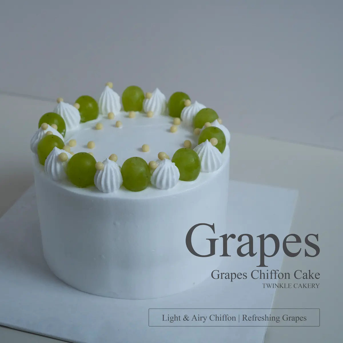 Top-down view showing geometric arrangement of whole green grapes on a white fresh cream cake.